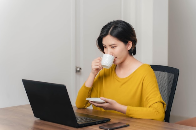 Femme asiatique femme d'affaires buvant du café pour guérir le concept de somnolence femme asiatique s'amusant à boire du café pendant le travail