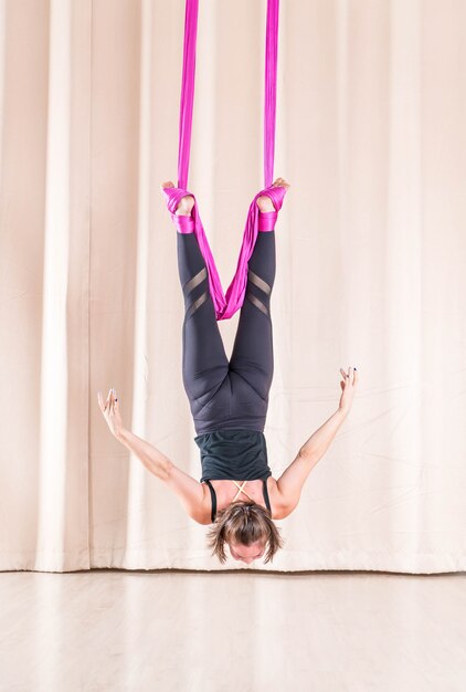 Femme asiatique de formation dans la salle de fitness avec des éléments de yoga mouche