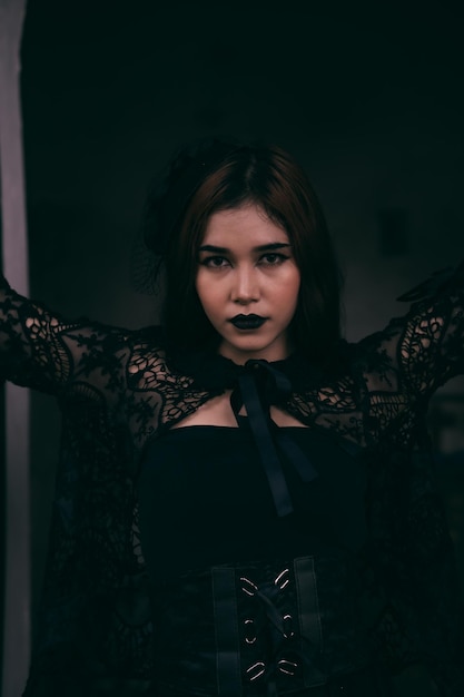 Une femme asiatique goth s'habille avec du maquillage noir et porte des vêtements noirs comme une femme effrayante à l'enterrement