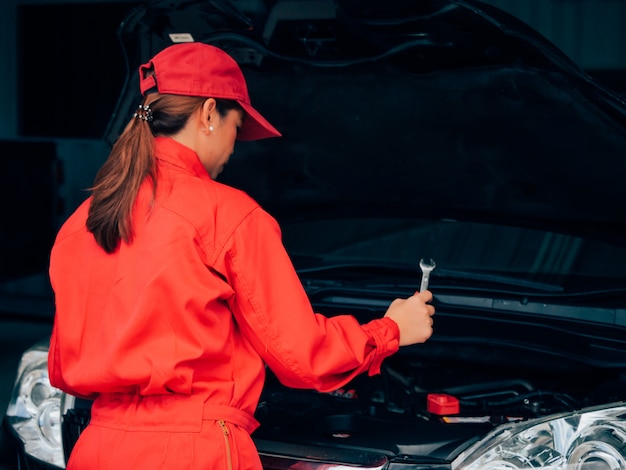 Femme asiatique d&#39;ingénierie réparant une voiture.