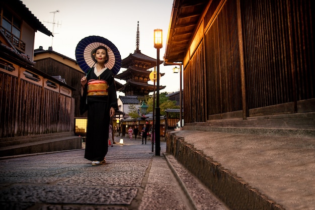 Femme asiatique avec kimono marchant à la pagode Yasaka à Kyoto