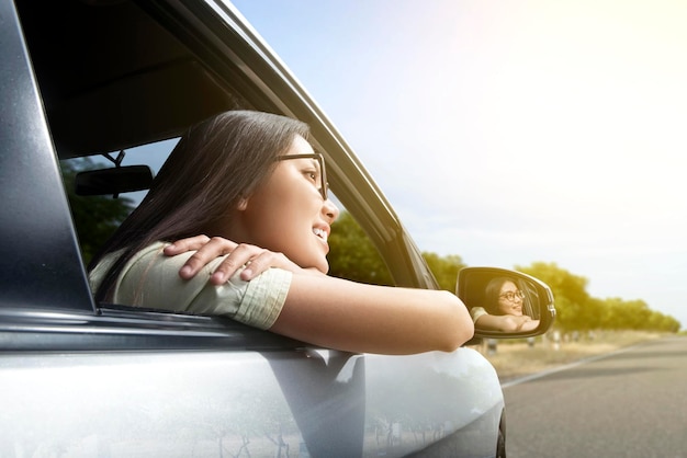 femme asiatique, à, lunettes soleil, s'appuyer, fenêtre, voiture