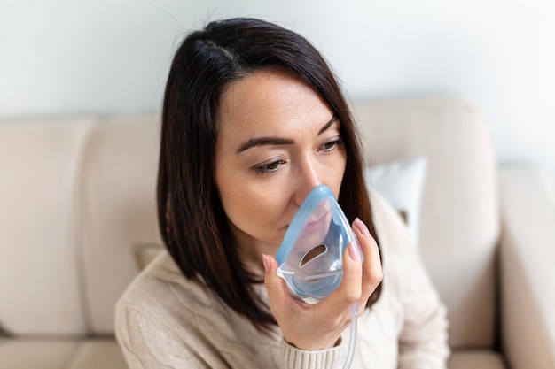 Une femme asiatique malade fabriquant un médicament d'inhalation est le meilleur médicament Une femme malade portant un masque à oxygène et subissant un traitement pour COVID-19 Une femme avec un inhalateur