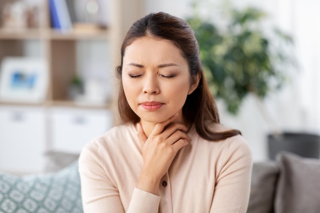 femme asiatique malade avec un mal de gorge à la maison
