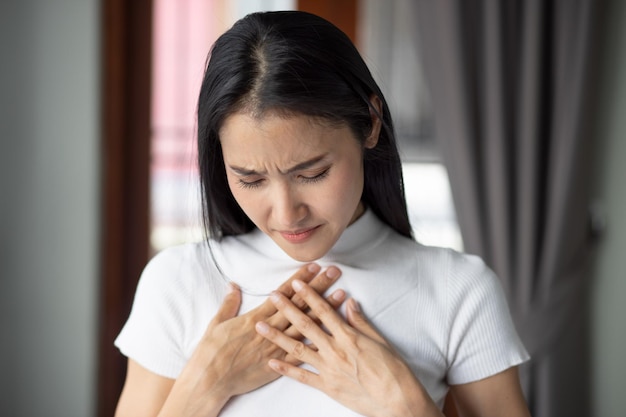 Femme asiatique malade avec problème d'indigestion reflux acide ou symptômes de gerd femme soins de santé soins du corps maladie douleur reflux acide pneumonie virus maladie concept