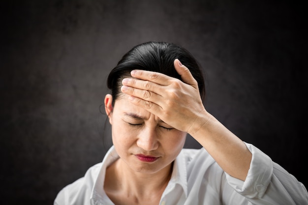 Femme asiatique malade touchant une tête avec mal de tête