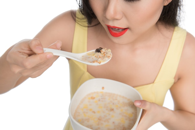 Femme asiatique mangeant un bol de céréales ou de muesli pour le petit déjeuner