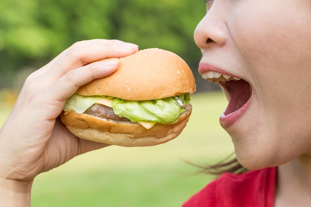 Femme asiatique mangeant un hamburger très faim.