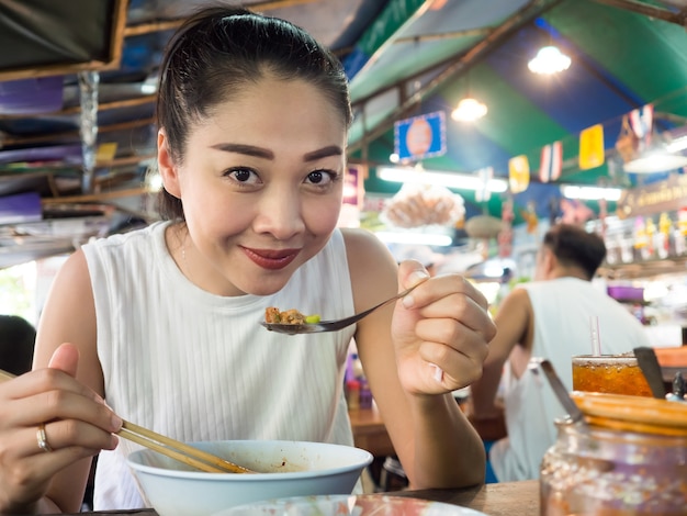 Femme asiatique, manger des nouilles dans un restaurant thaïlandais en Thaïlande.