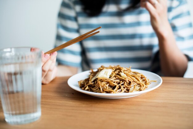 Femme asiatique, manger, nouilles