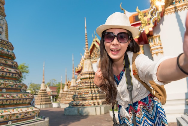 Femme asiatique marchant dans l'étroite ruelle de l'ancien temple entouré par le patrimoine. Elle parle d'une photo de selfie.