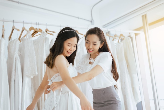 Femme asiatique mariée essayant une robe de mariée