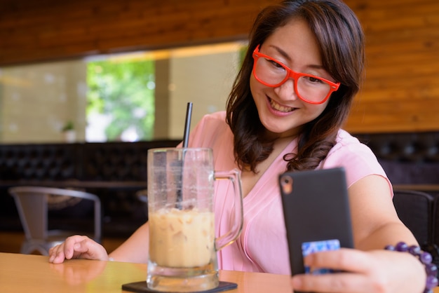 Femme asiatique mature se détendre au café