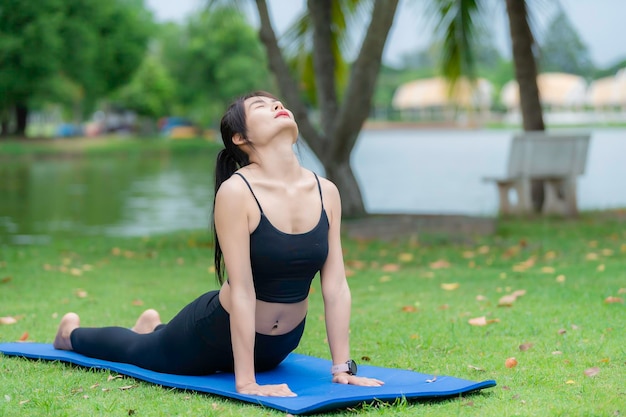 Femme asiatique mince faisant de l'exercice seule dans le parcFatiguée du concept de yoga workoutPlay