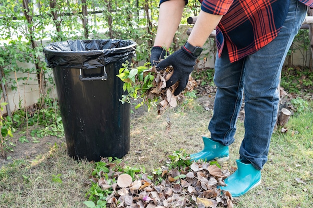 Une femme asiatique nettoie et collecte des poubelles sèches laisse des ordures dans le parc, recycle, protection de l'environnement. Équipe avec projet de recyclage à l'extérieur.