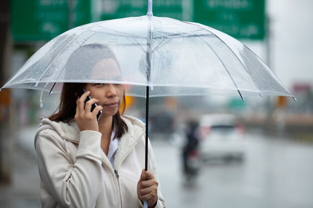 Femme asiatique avec un parapluie sous la pluie