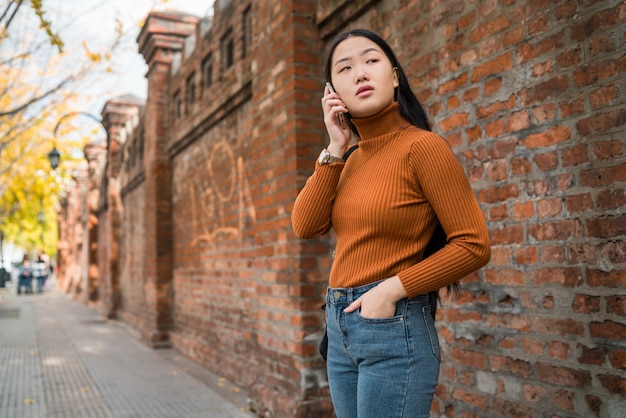 Femme asiatique parlant au téléphone.