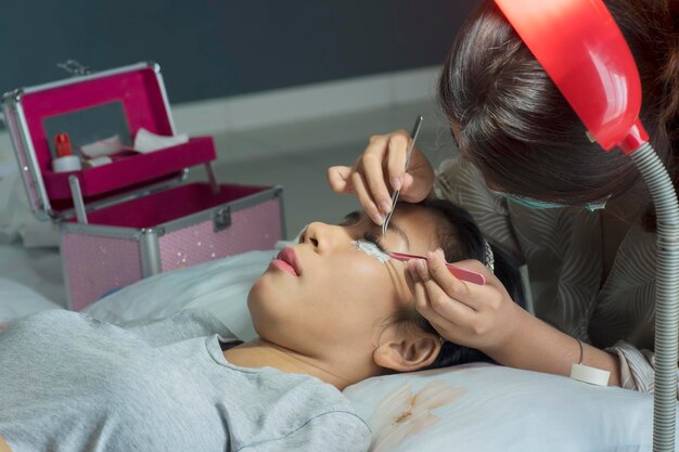 Une femme asiatique pendant un traitement d'extension des cils