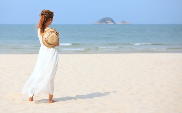 Femme asiatique sur la plage en regardant la mer