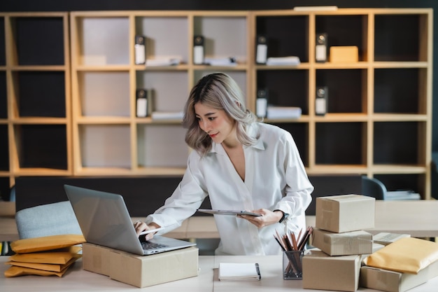 Femme asiatique PME entrepreneur startup e-business propriétaire après avoir vérifié la commande de la livraison des achats en ligne au succès des clients shopping small businessxA