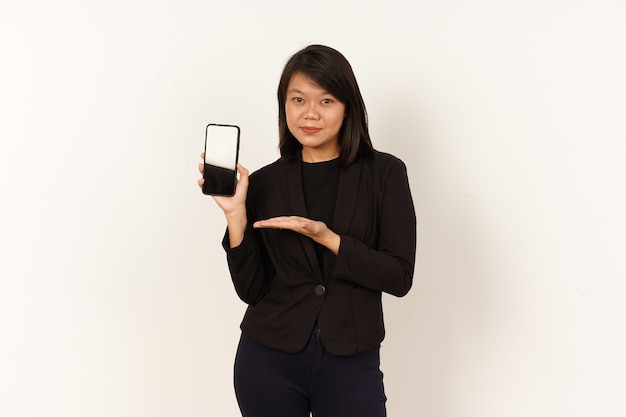 Femme asiatique portant un costume noir tenant un smartphone et montrant un écran de smartphone vierge isolé