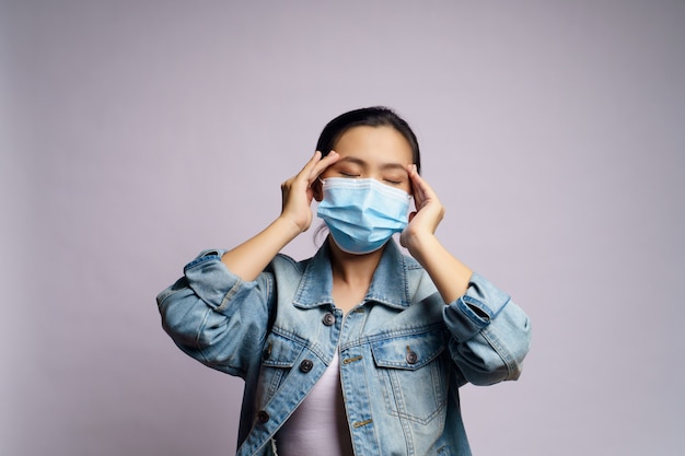 Une femme asiatique portant un masque protecteur était malade avec des maux de tête isolés.