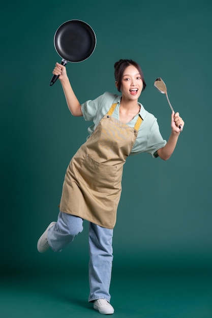 femme asiatique, porter, tablier, et, tenue, a, casserole