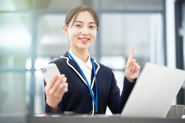 Femme asiatique posant avec son index au bureau