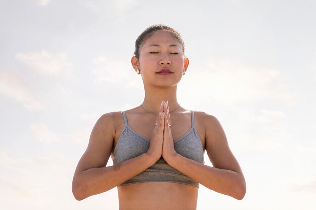 Une femme asiatique pratiquant le yoga en position de prière