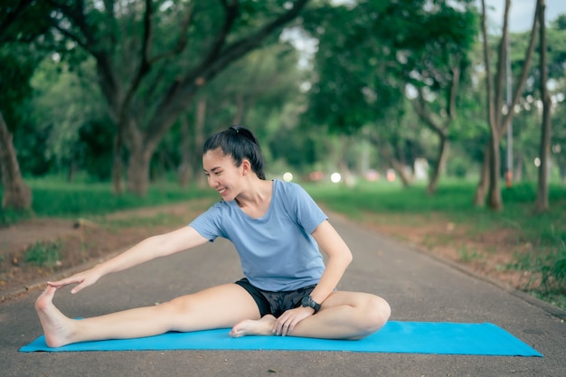 Une femme asiatique pratique le yoga et médite au parc. Mode de vie sain et concept de yoga.