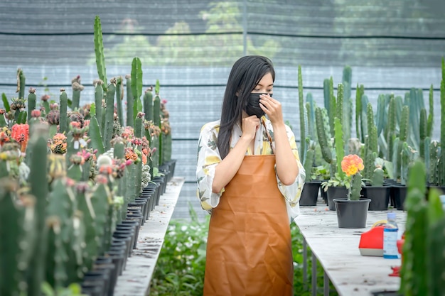 Femme Asiatique En Prêt-à-porter Dans La Coupe De La Propagation Des Cactus. à La Crèche