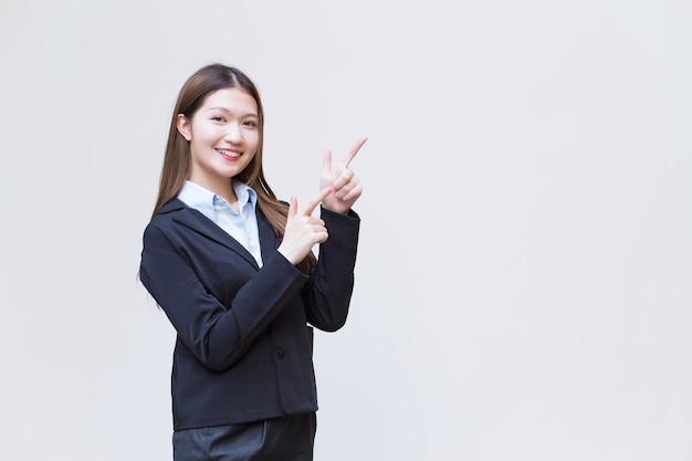 Une femme asiatique qui a les cheveux longs porte un costume noir avec une chemise bleue