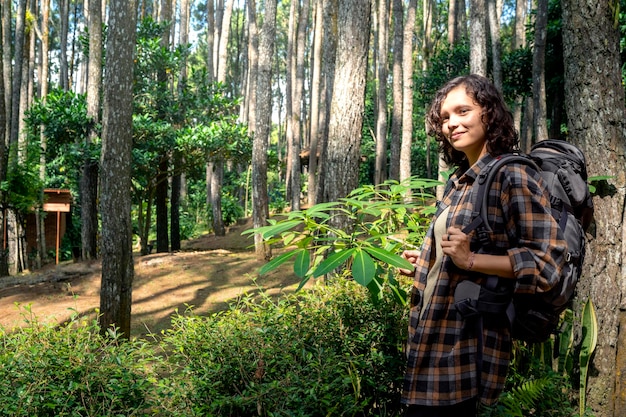 Une femme asiatique en randonnée dans la forêt.