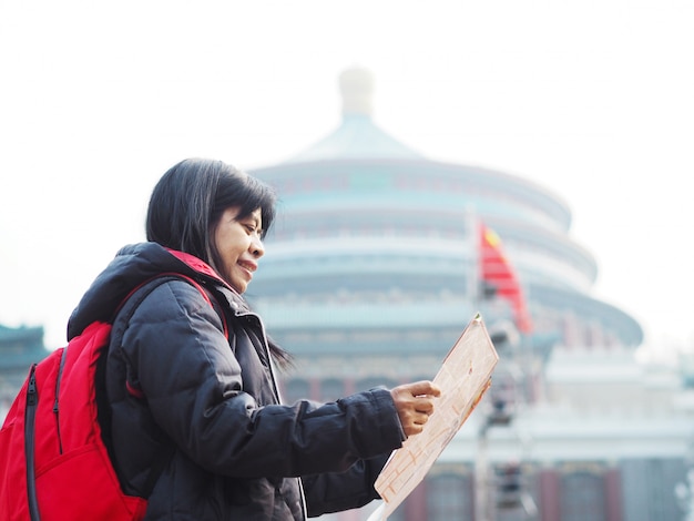 Photo femme asiatique en regardant la carte dans le grand hall de la place du peuple de chongqing en chine.