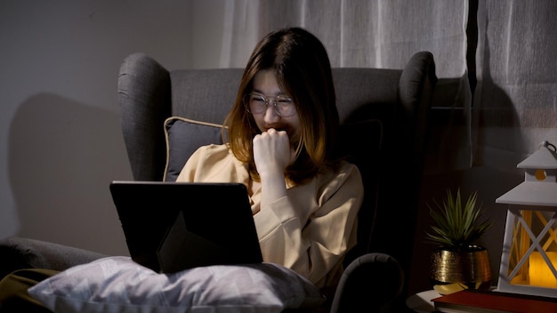 Femme Asiatique Regardant Un Film Sur Tablette La Nuit à La Maison. Mode De Vie Relaxant Et Récréatif.
