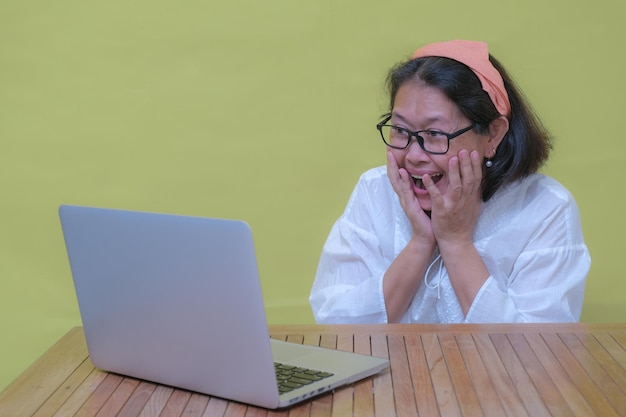 Photo une femme asiatique a regardé un ordinateur portable étonnamment