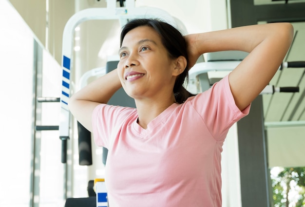 Femme asiatique de remise en forme se réchauffer avant de faire de l'exercice dans une salle de sport