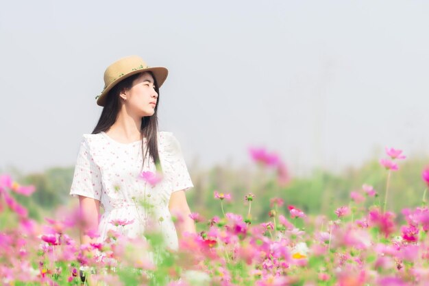 Femme asiatique avec une robe blanche relaxante sur le champ de fleurs de Margaret Aster dans le jardin