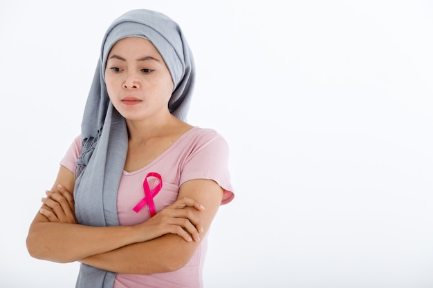 Une femme asiatique avec un ruban de sensibilisation au cancer du sein rose isolé sur fond de studio espace copie vierge rose, soins de santé, concept de médecine