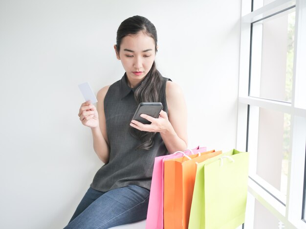 Femme asiatique avec sac à provisions dans le salon