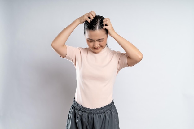 Femme asiatique se grattant la tête debout isolé sur fond blanc