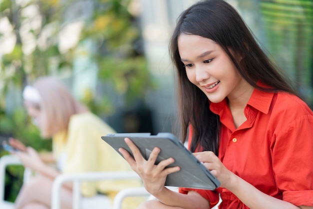 Femme asiatique séduisante intelligente tissu décontracté travail indépendant loisirs se détendre en travaillant avec une tablette et un smartphone au café-restaurant style de vie urbain nomade numérique travaillant dans un espace de travail co