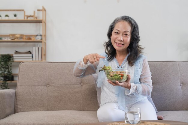 Femme asiatique senior mangeant de la salade végétarienne fraîche et propre à la maison Concept de soins de santé
