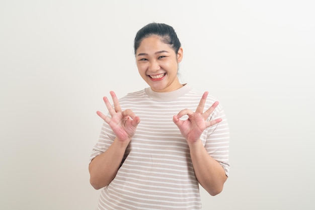 Femme asiatique avec signe de la main ok sur fond blanc