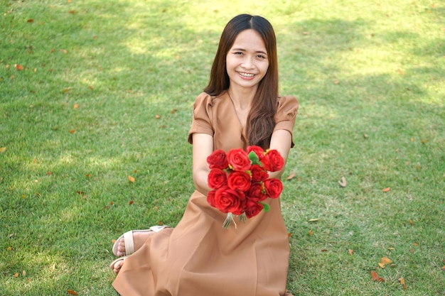 Femme asiatique souriant joyeusement parmi de belles fleurs