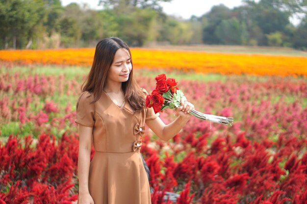 Femme asiatique souriant joyeusement parmi de belles fleurs