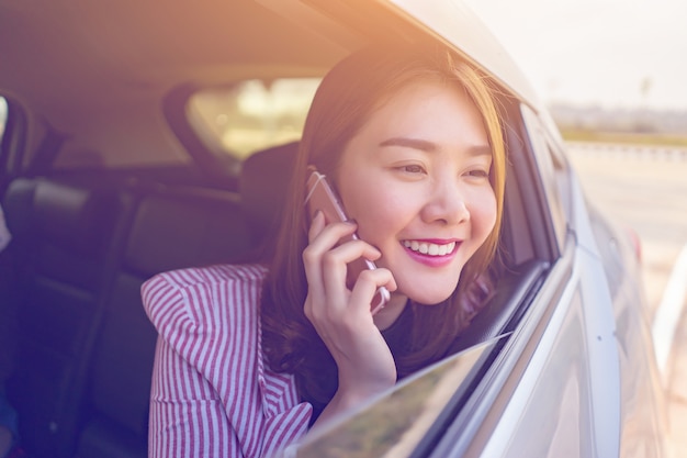 Femme asiatique souriante et parler par téléphone mobile sur un téléphone cellulaire