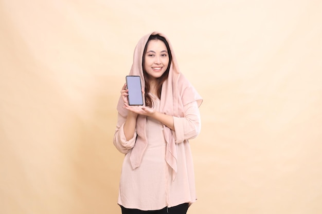femme asiatique sourire joyeux à la caméra main présente écran de téléphone portable gadget jeune belle pour bu