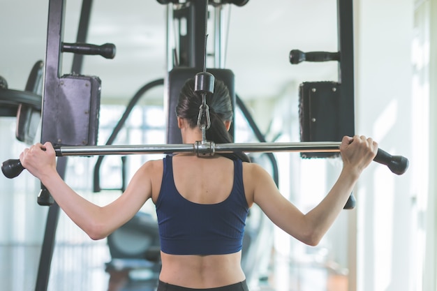 femme asiatique de sport s&#39;entraîner avec une machine de musculation