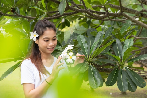 Femme asiatique, t-shirt blanc, plumeria, cheveux